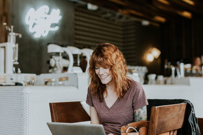 woman looking at laptop and smiling