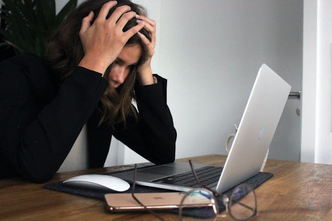 woman looking stressed at laptop