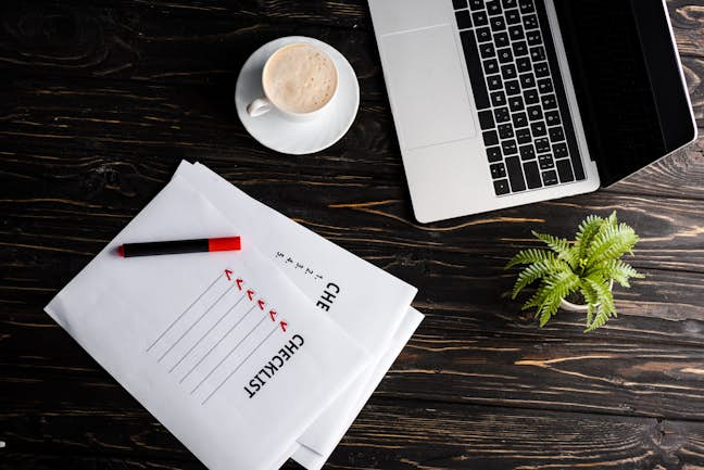 Laptop, coffee and checklist on desk