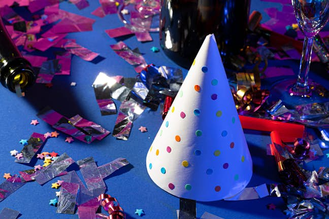 party hat with polka dots and confett on a table