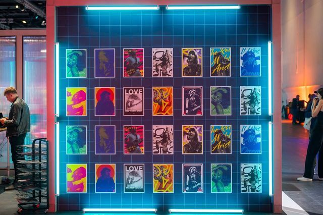 A grid of unique AI-generated album covers on a neon-lit wall at Xerocon