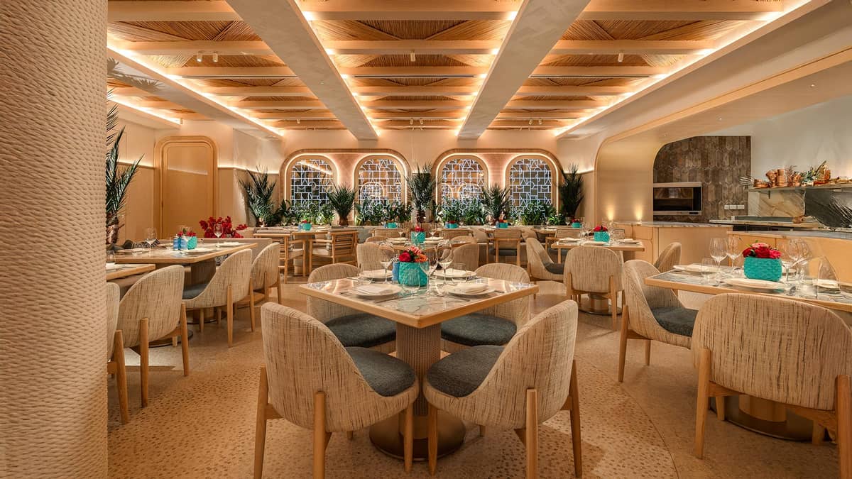 Dining room with a lit slatted ceiling and lattice windows | Nammos London