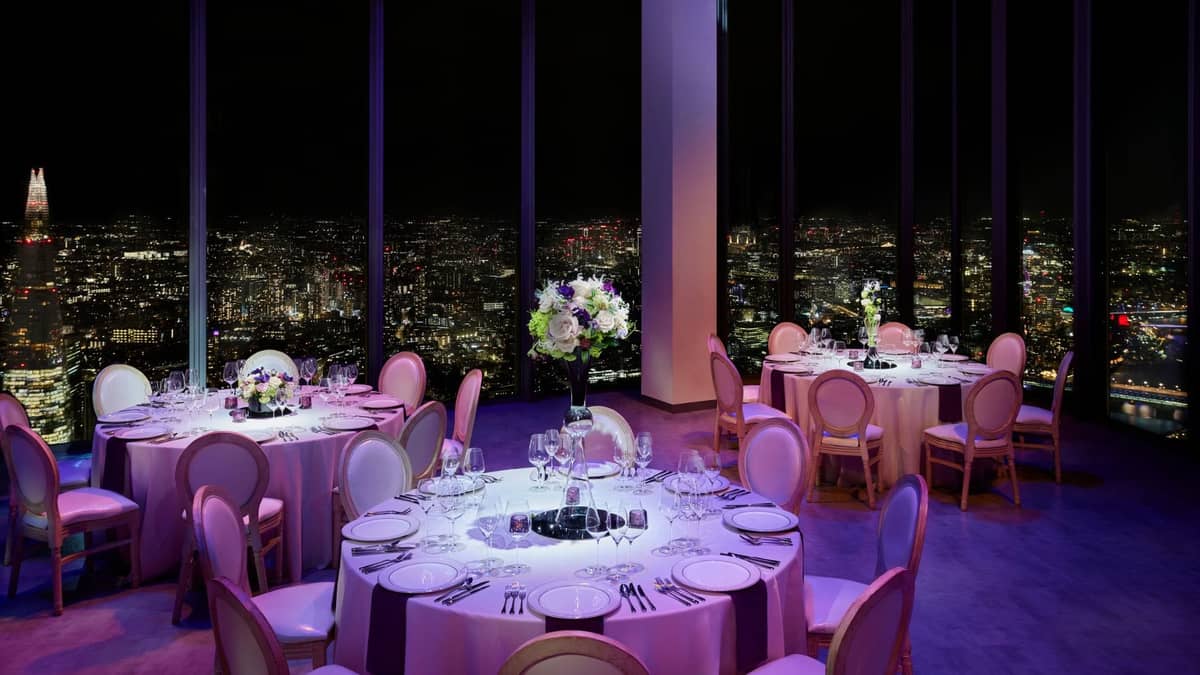 Round tables set for dinner with night views over London | Horizon 22 Events by Searcys