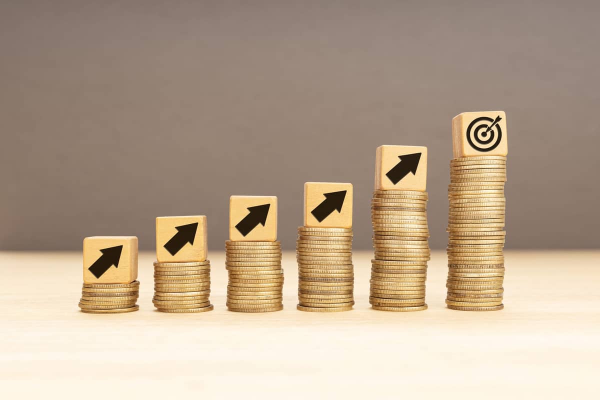 Stacked gold coins leading to a target