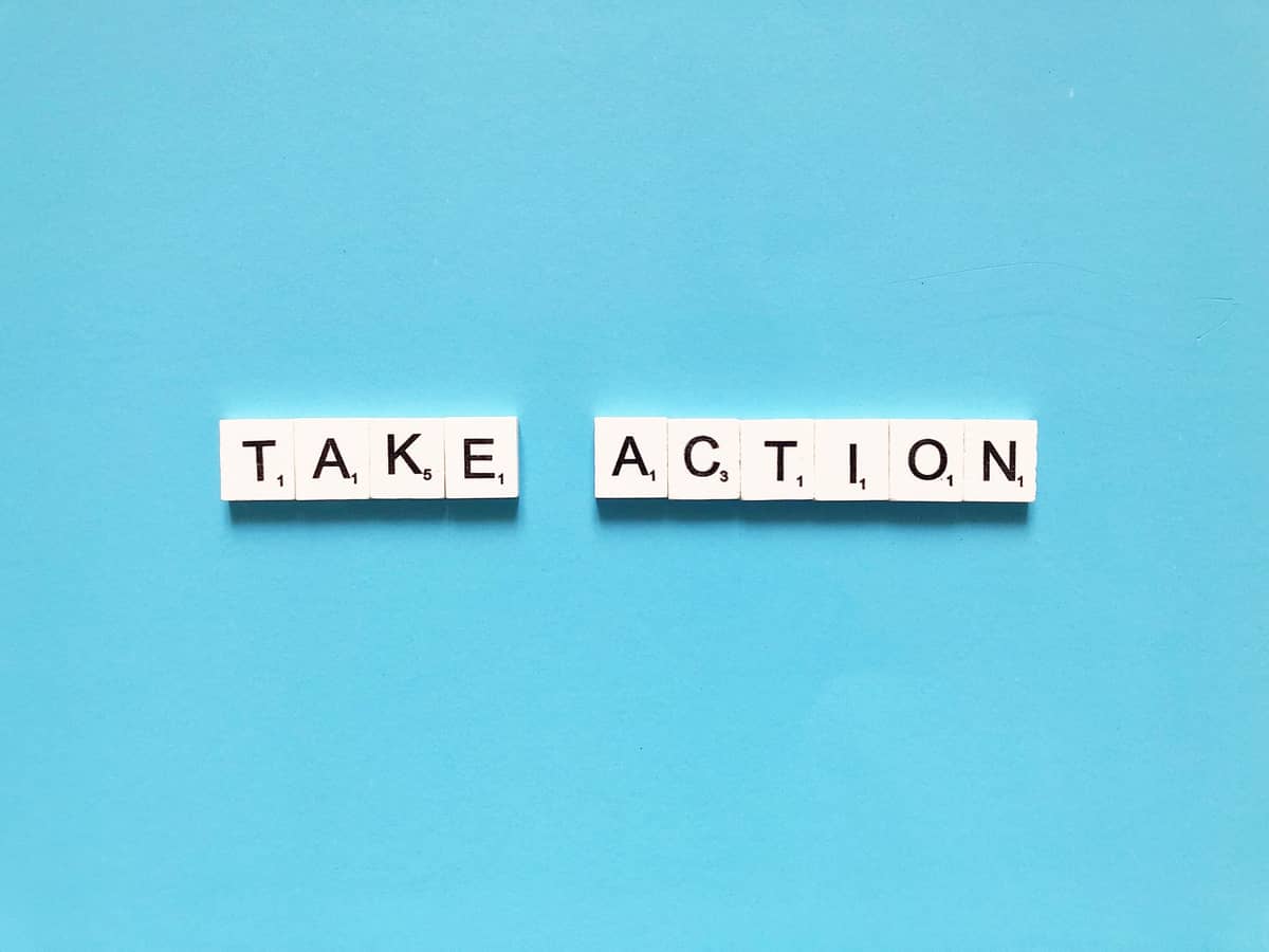 take action scrabble letters on blue blackground