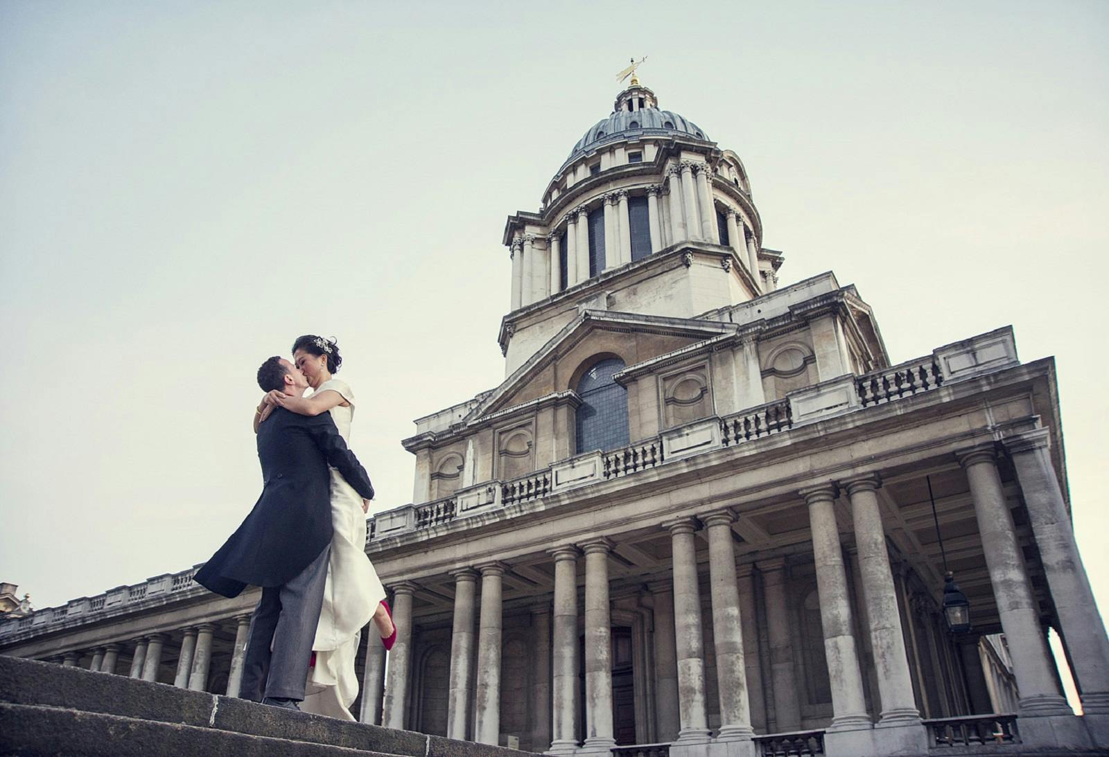 Couple embracing in The Painted Hall, a romantic wedding venue with elegant architecture.