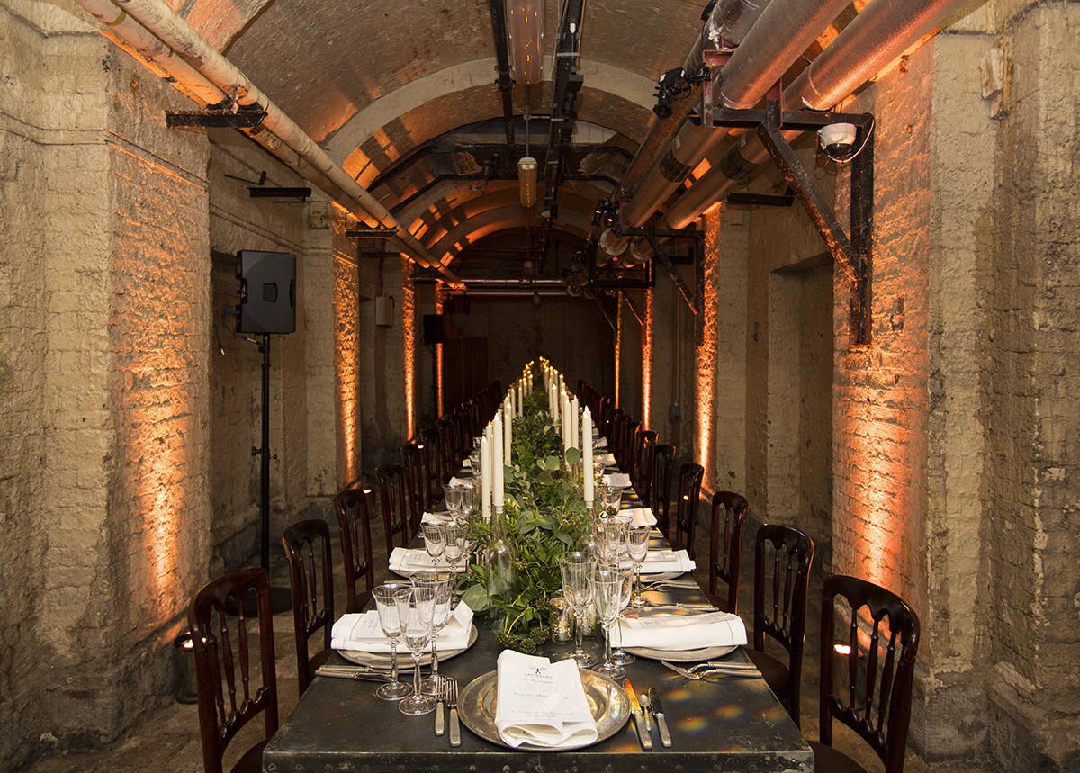 Elegant dining table with candlelight in Somerset House's industrial-style venue.