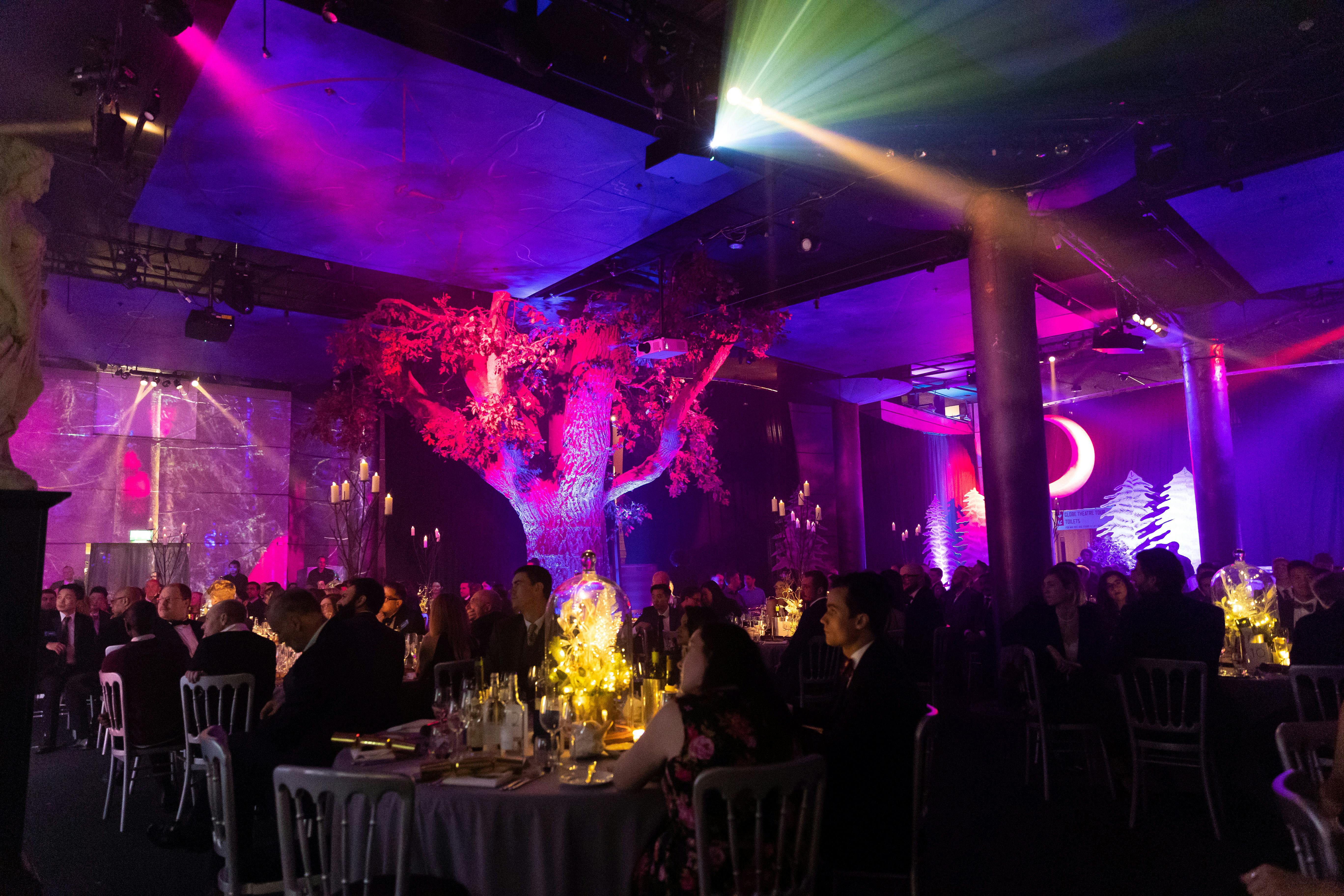 Elegant event space at Underglobe, featuring illuminated tree for gala or dinner.