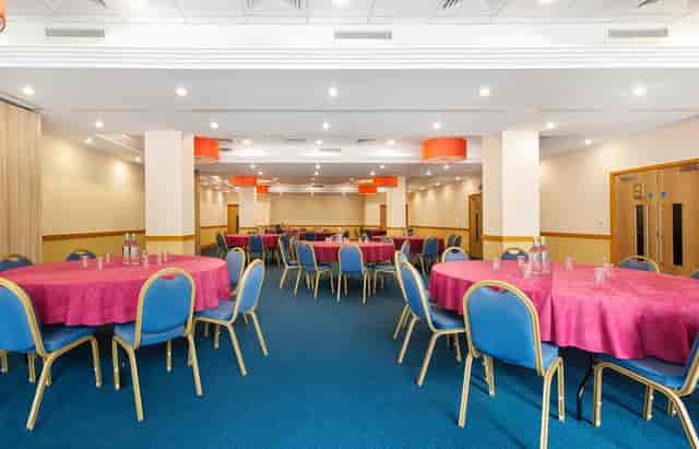 Domatic Suite banquet hall with magenta gala tables for corporate events.