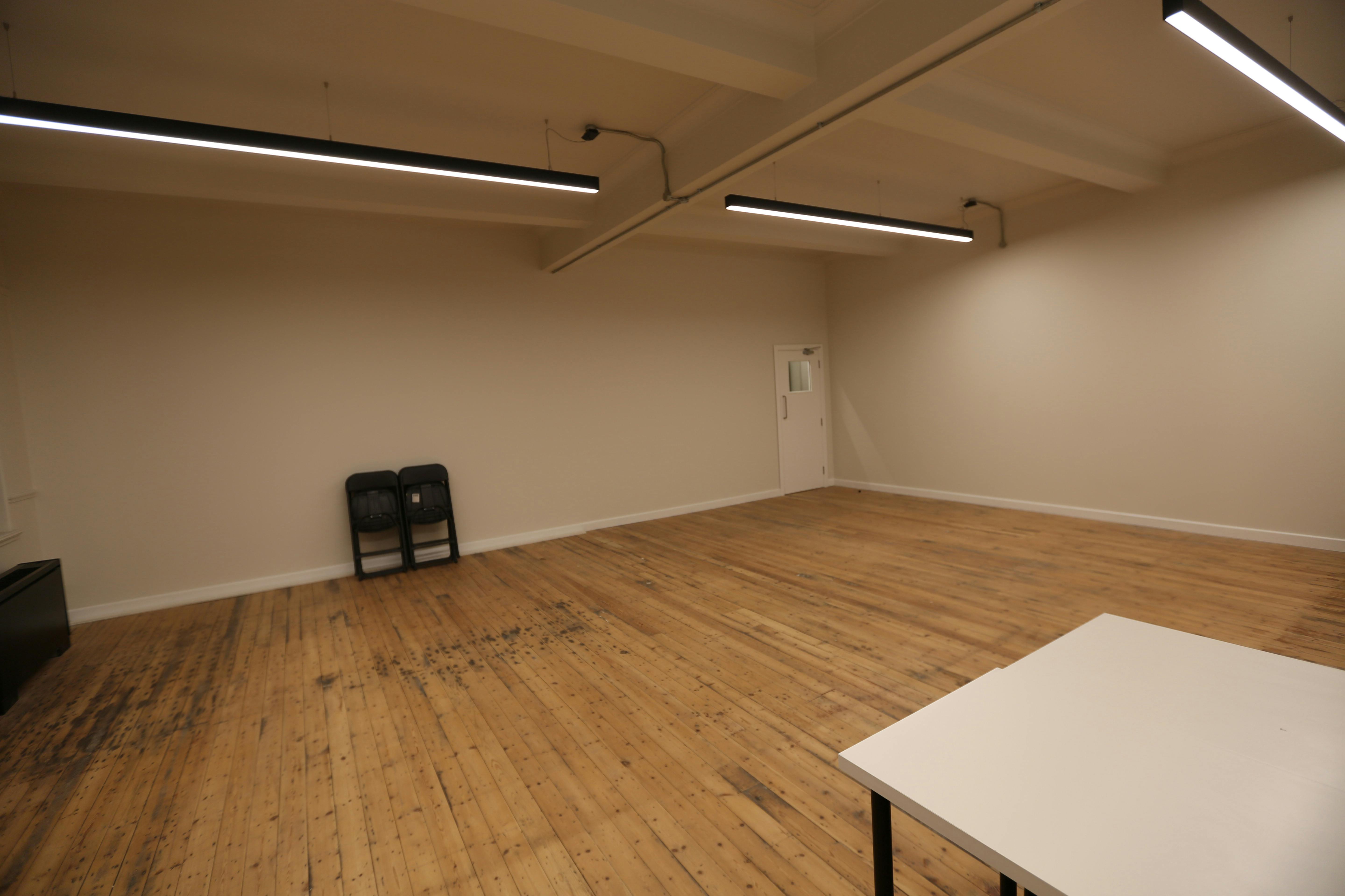 Spacious Studio 5 meeting room with wooden floors, ideal for workshops and events.