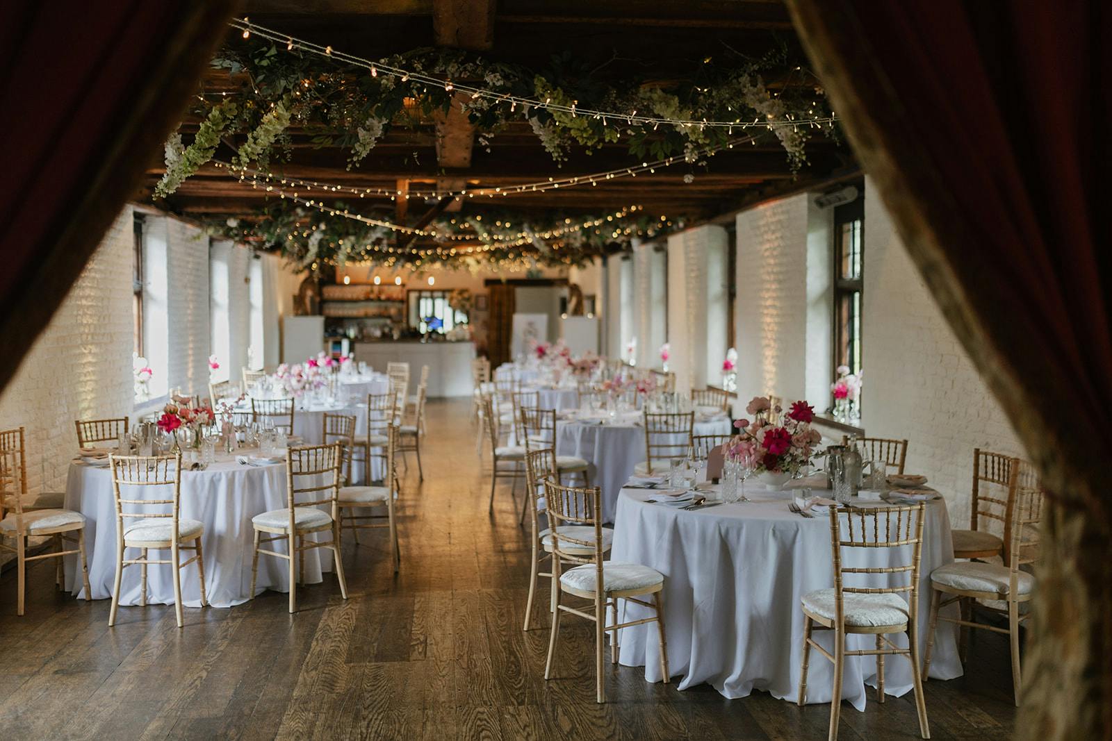 Elegant Tudor Gallery event space with round tables, perfect for weddings and upscale gatherings.