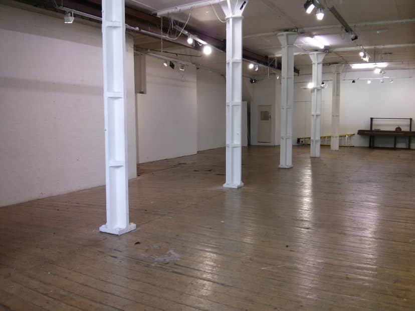 Spacious Ground Floor Gallery venue with wooden flooring for events and workshops.
