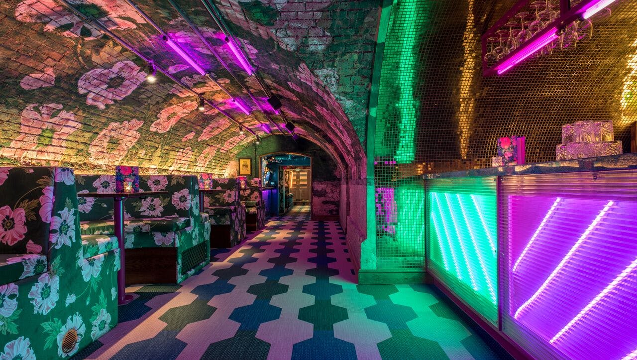 Vibrant event space at Blame Gloria with neon lighting, perfect for gatherings and parties.