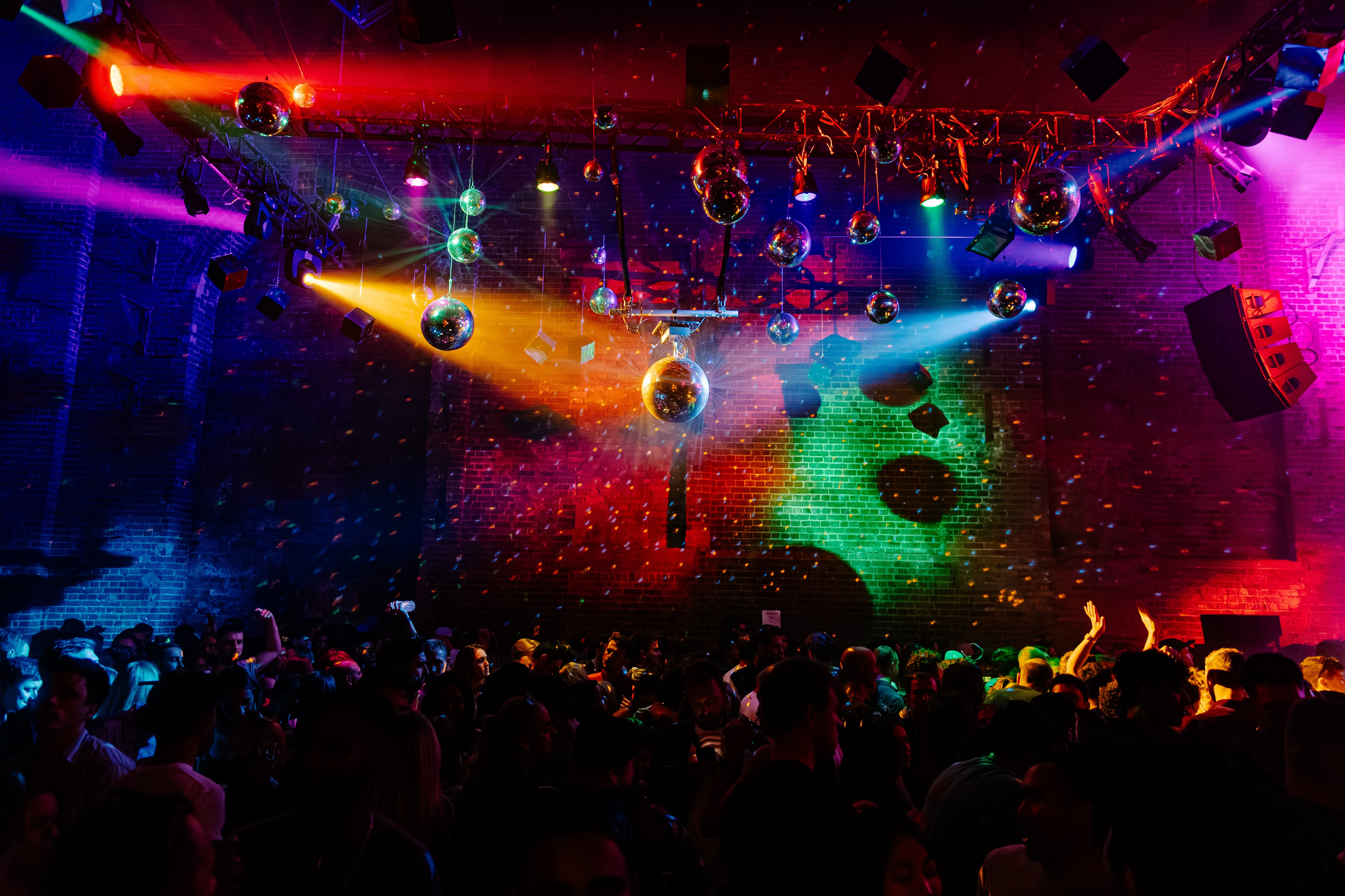 Vibrant event space at Village Underground with colorful lighting and disco balls. - Banner