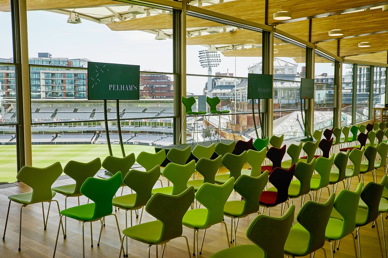 Modern event space at Lord's Cricket Ground with vibrant chairs for corporate meetings.