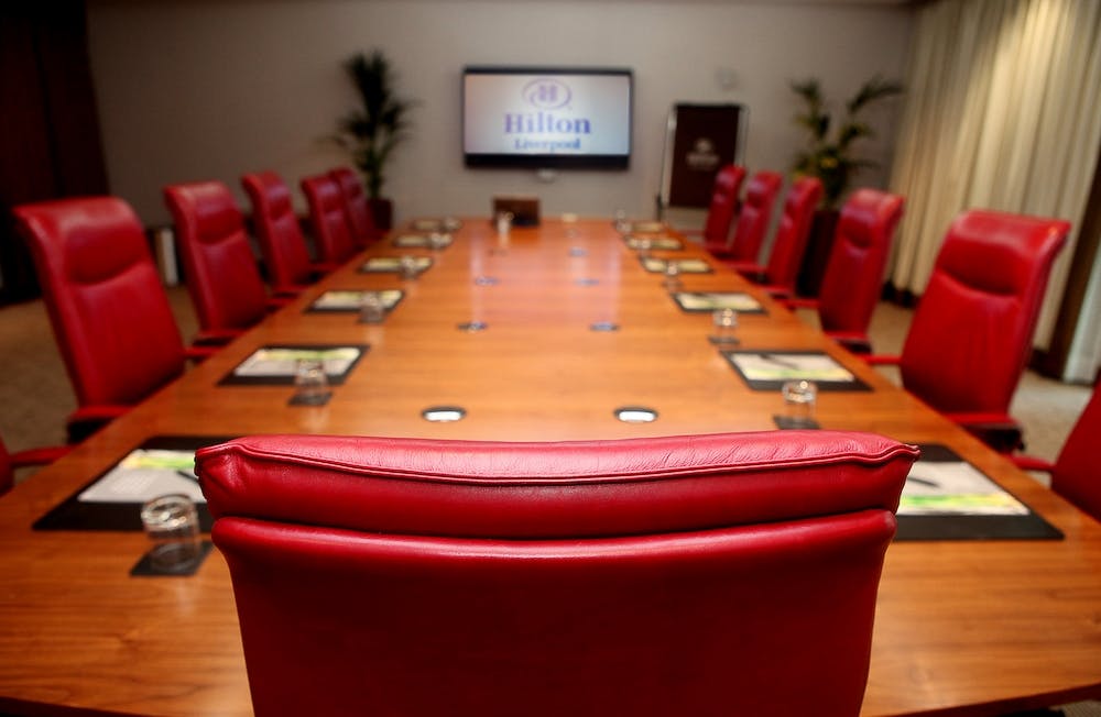 Boardroom at Hilton Liverpool: large wooden table, red leather chairs, corporate events.