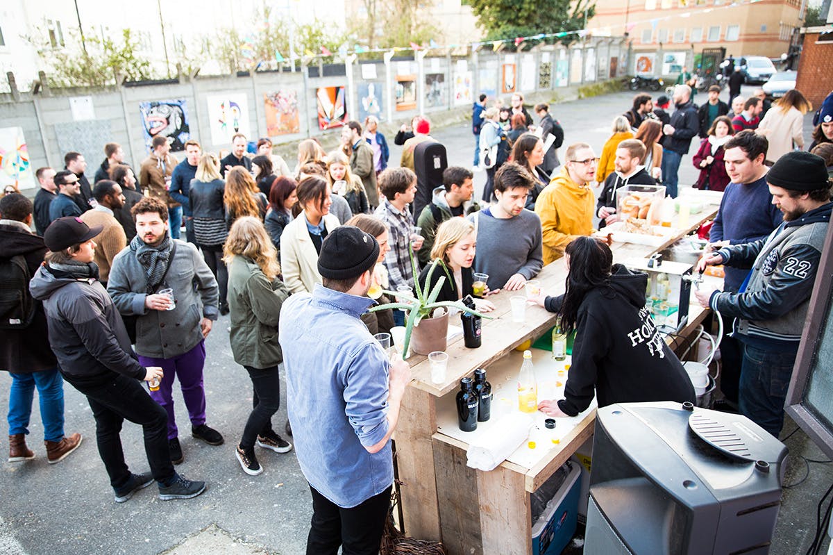 Vibrant outdoor market with lively crowd at The Village Green for networking events.