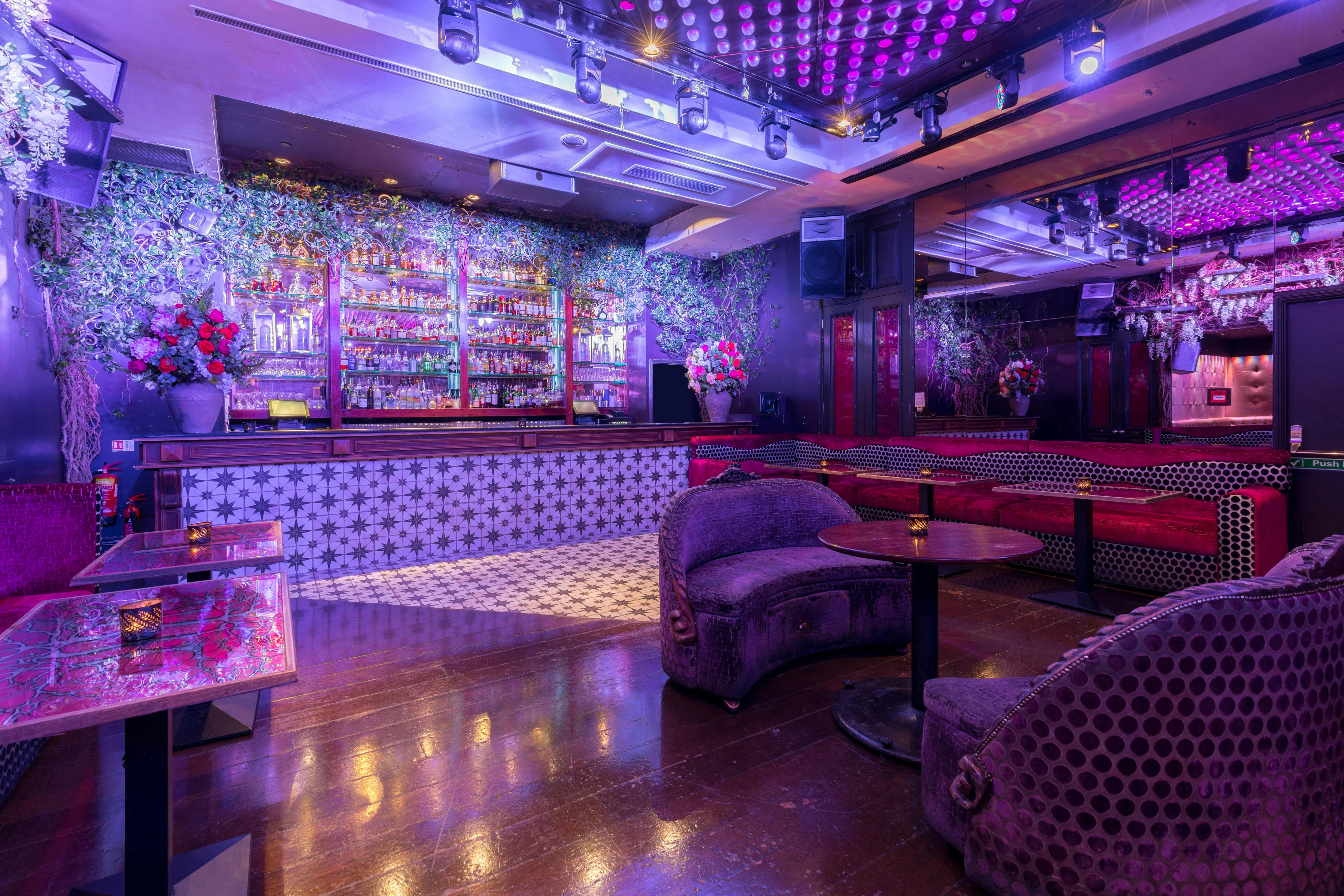 Vibrant event space with stylish bar and floral decor for cocktail receptions.