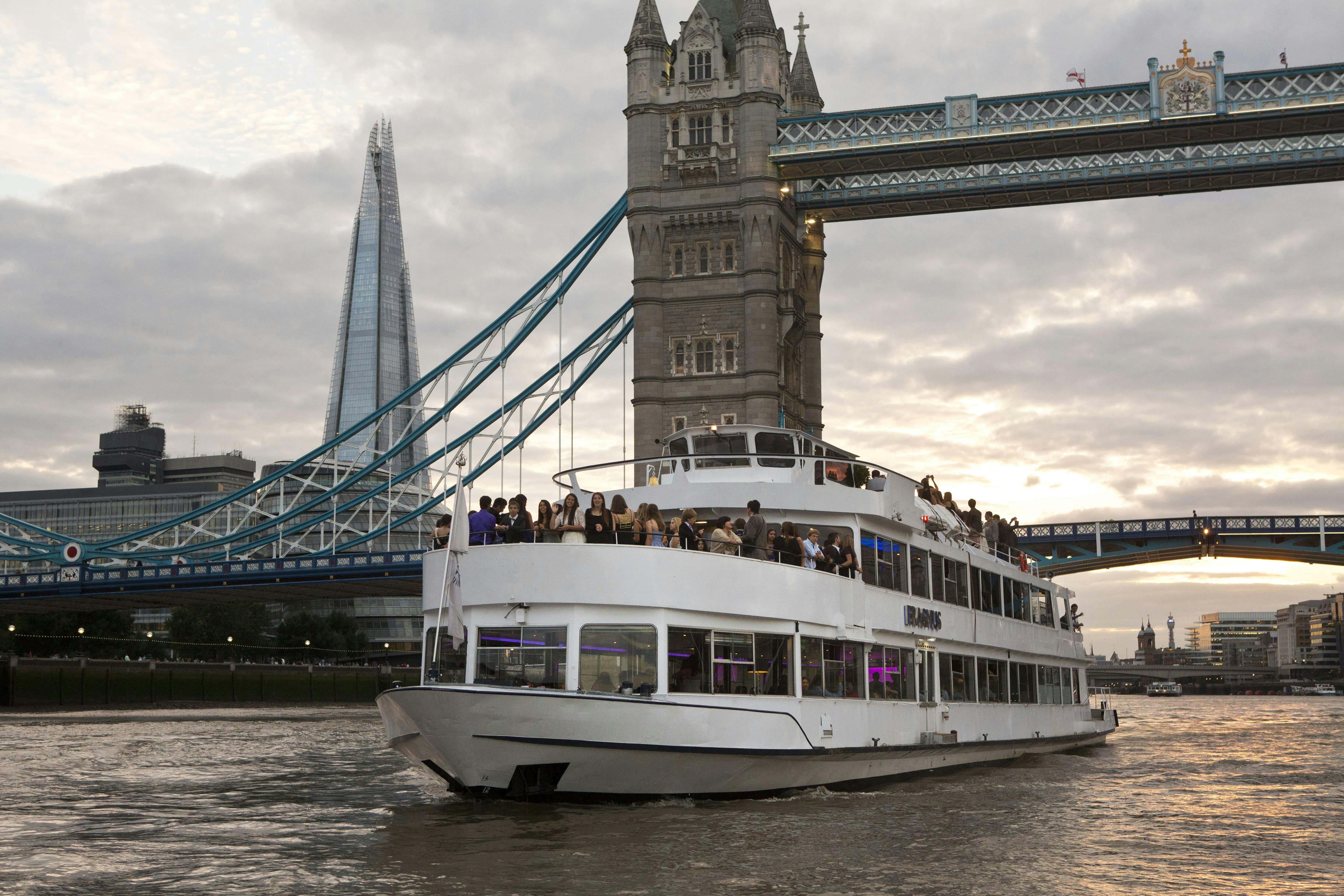 Stylish event boat M.V. Erasmus cruising Thames near Tower Bridge, ideal for networking events.
