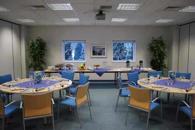 Lugano meeting room with purple tables, ideal for conferences and networking events.