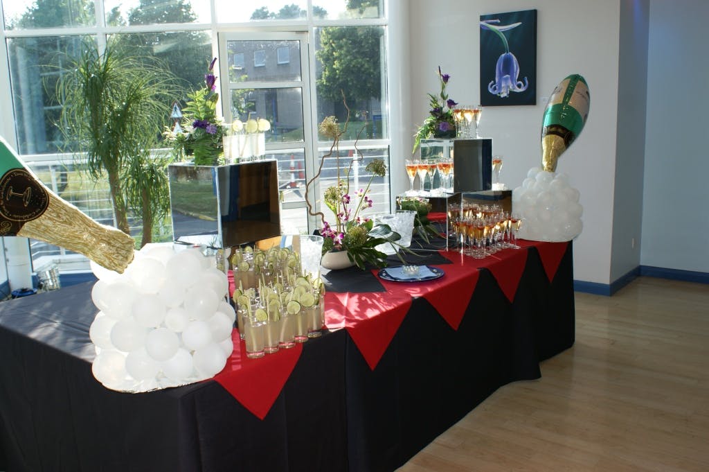 Blue Cafe Bar event setup with champagne display, balloons, and floral arrangements.