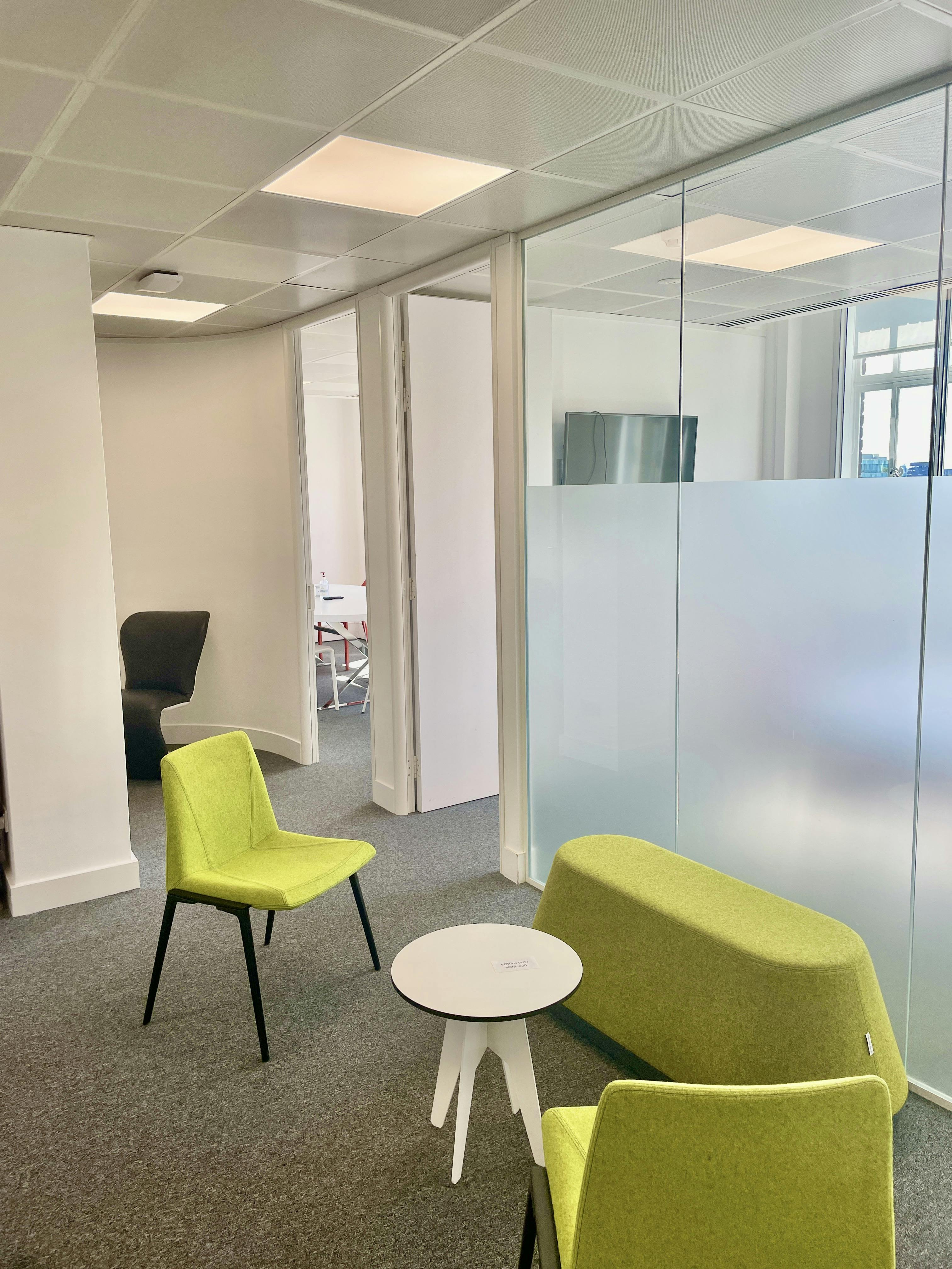 Modern meeting room for 14 with green seating, ideal for brainstorming sessions.
