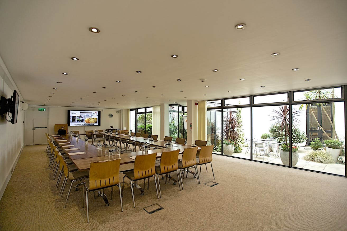 Modern meeting room with conference table, ideal for professional gatherings and presentations.