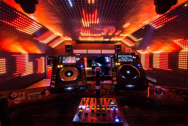 Vibrant DJ booth with LED lights at Vauxhall Arches for music events.