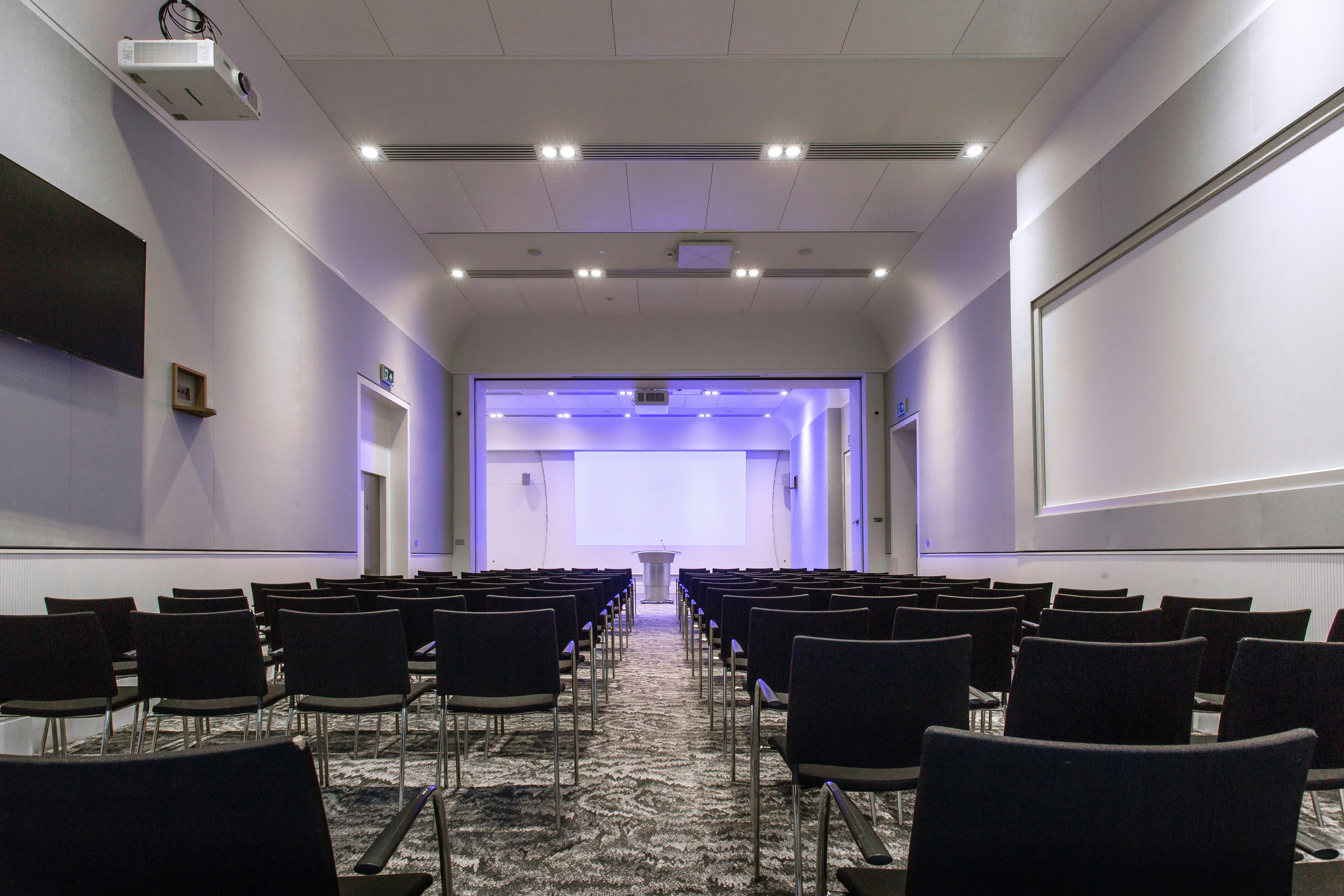 Modern event space in Prince Philip House with black chairs for presentations and meetings.