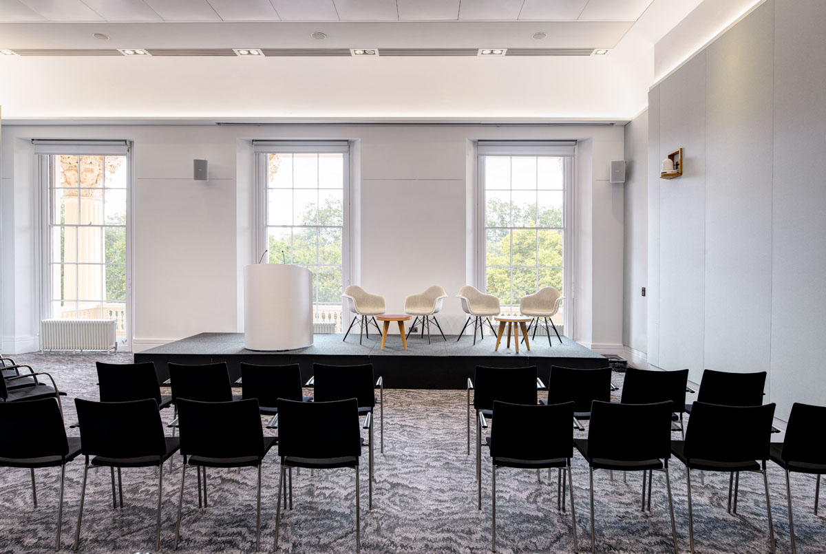 Al Qasimi at Prince Philip House, minimalist stage for corporate panel discussion.