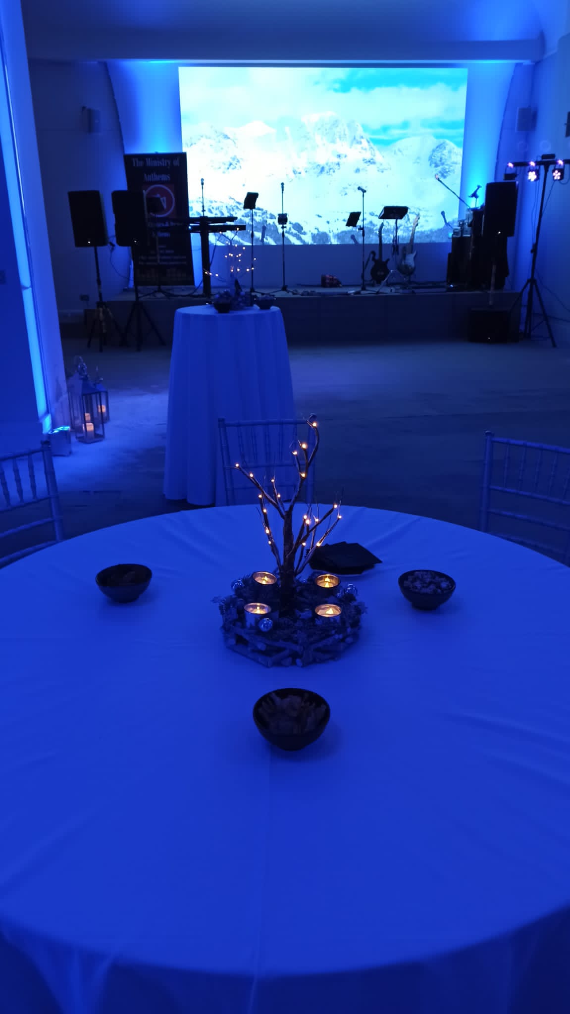 Elegant table setup with illuminated branches at Al Qasimi, ideal for evening events. - Banner