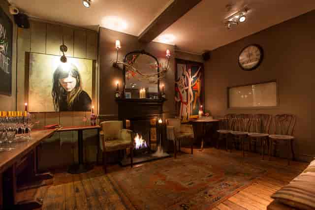 Cozy pub private event space with fireplace, perfect for networking mixers and small receptions.