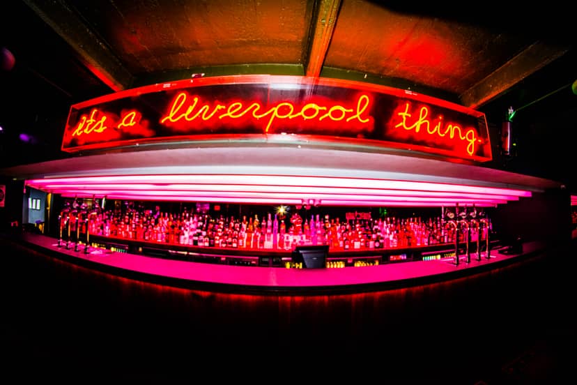 Vibrant bar venue with neon sign, ideal for networking events and social gatherings.