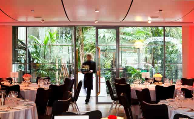 Elegant dining area in The Garden Room, Barbican Centre for corporate events and celebrations.