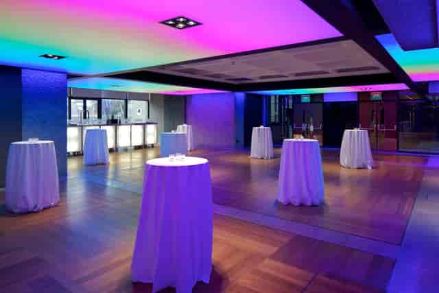 Modern event space at Barbican Centre with elegant high-top tables for cocktail receptions.