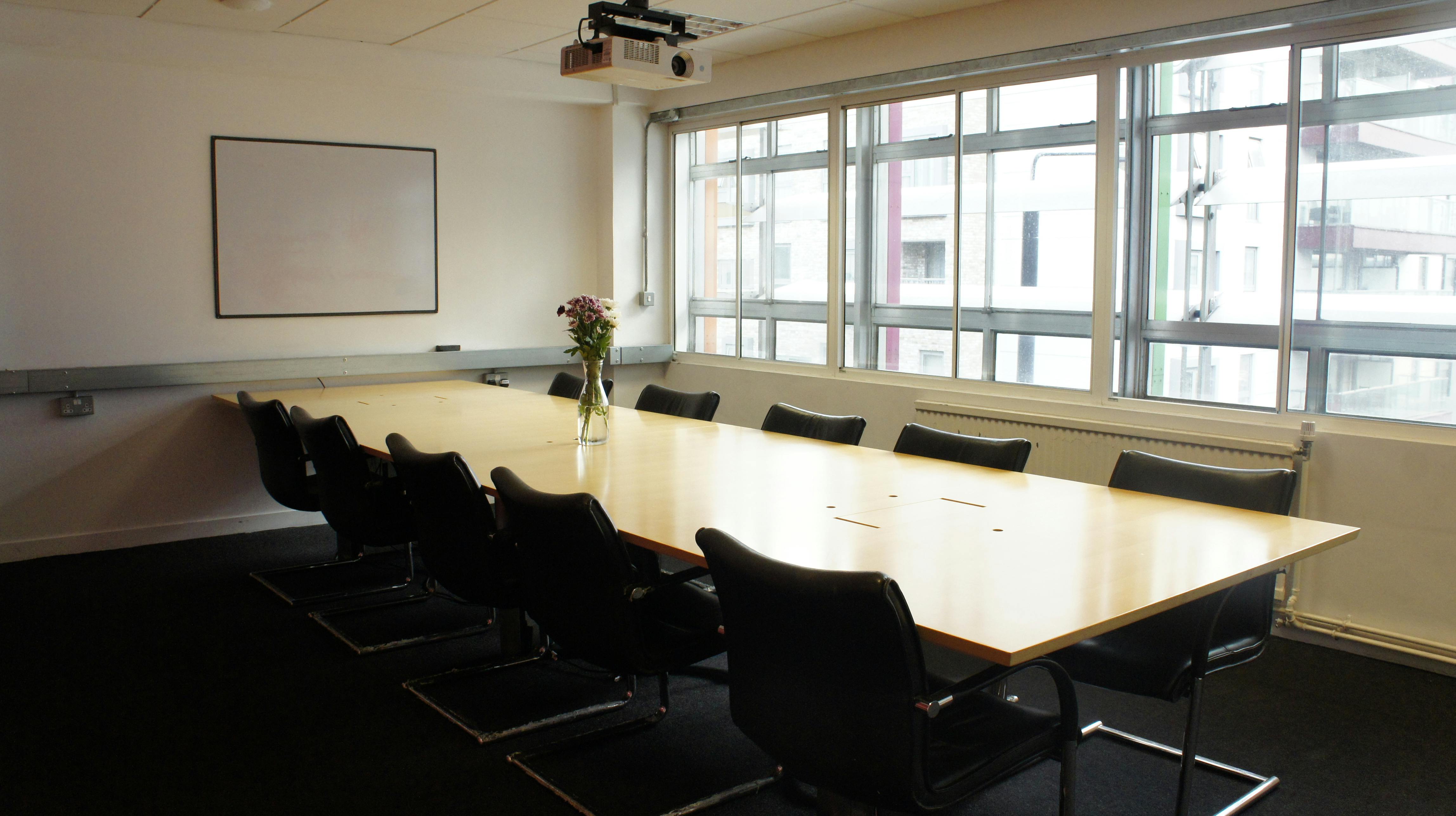 Modern conference room with large windows, ideal for meetings and presentations.