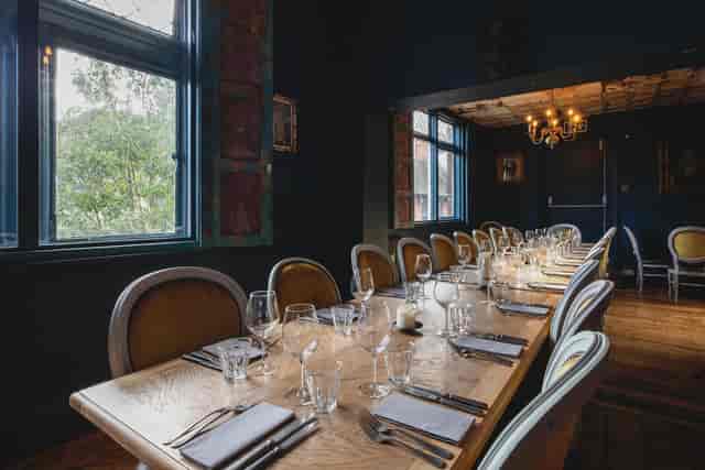 Elegant private dining room with long wooden table for intimate gatherings and corporate dinners.