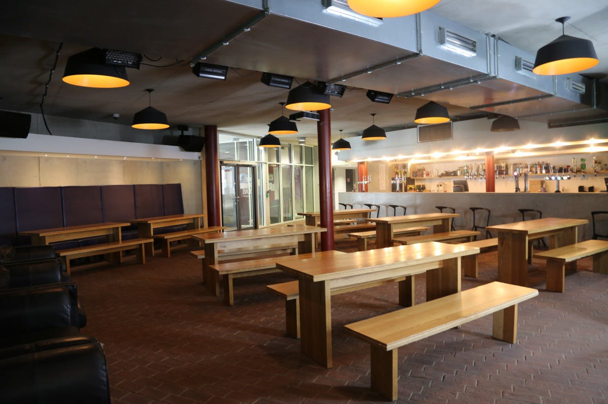 Three Tuns Bar event space with wooden tables, ideal for networking and casual gatherings.