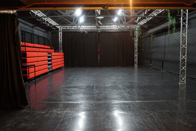 Versatile event space with red seating and black curtains at Young Actors Theatre Islington.