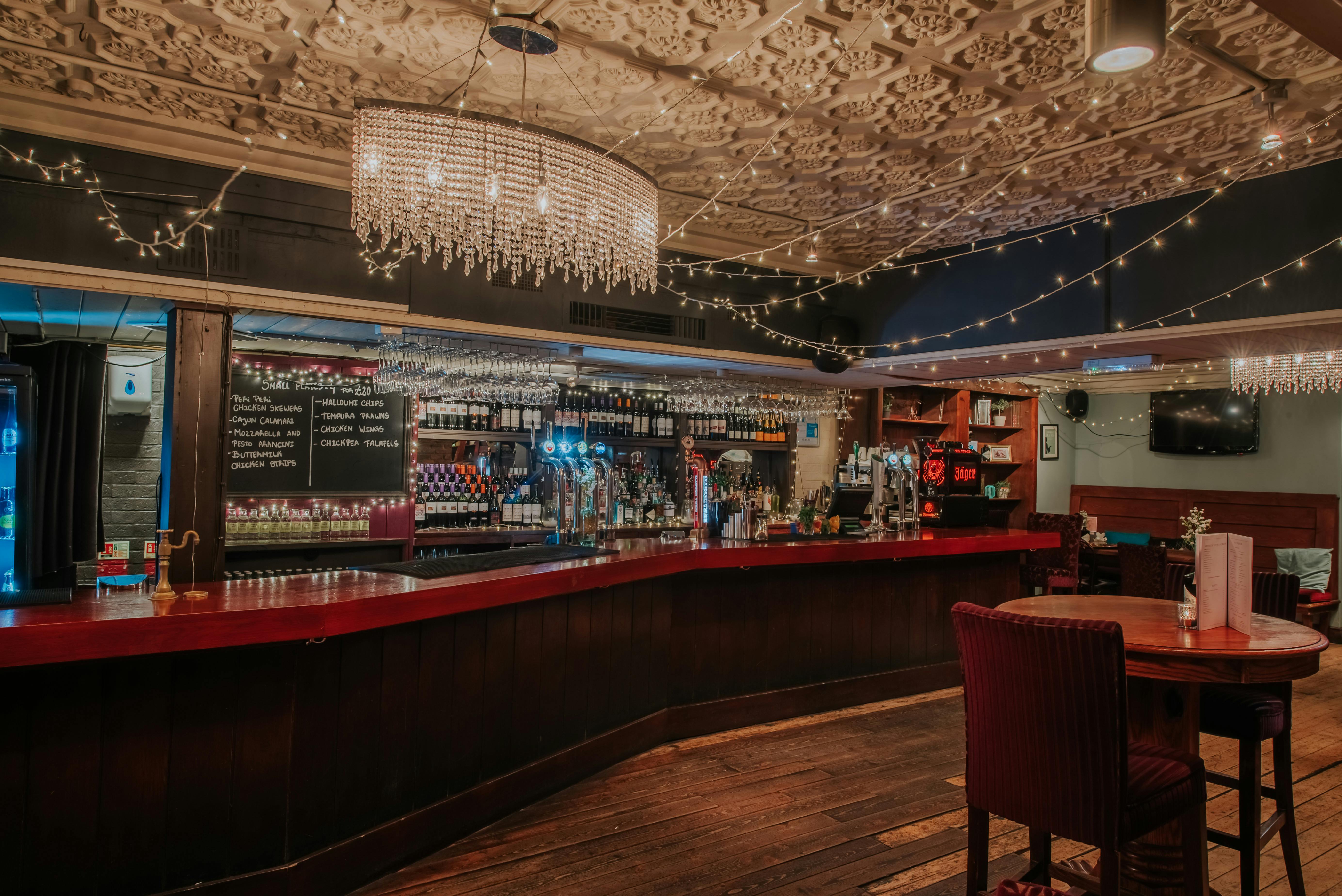 Stylish bar area with chandelier, ideal for intimate gatherings and networking events.