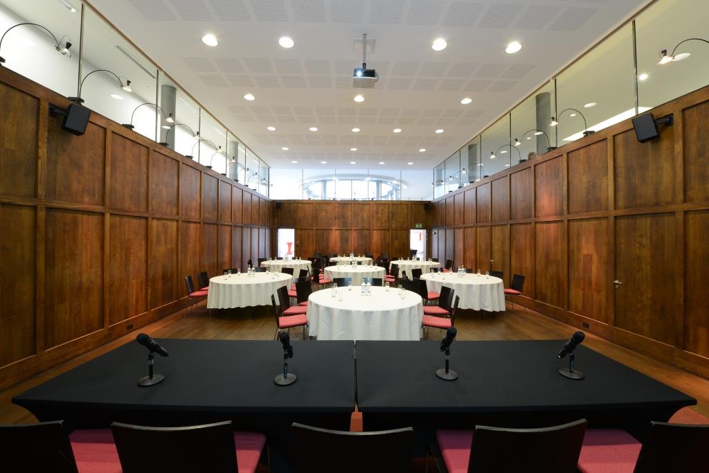 St Martins Hall meeting room with round tables, ideal for events and presentations. - Banner