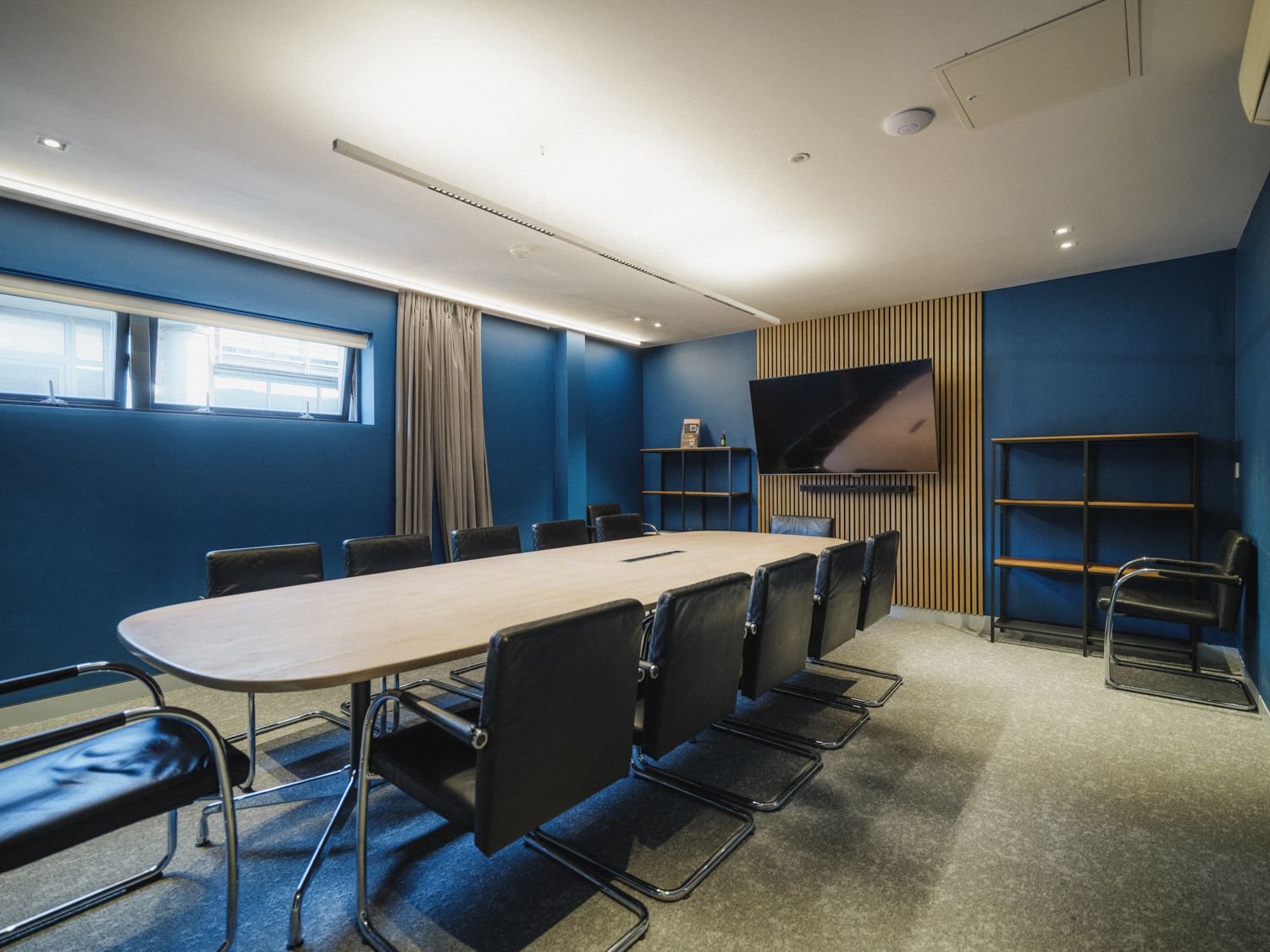 Modern meeting room at FACT Liverpool with sleek table and blue walls for conferences. - Banner