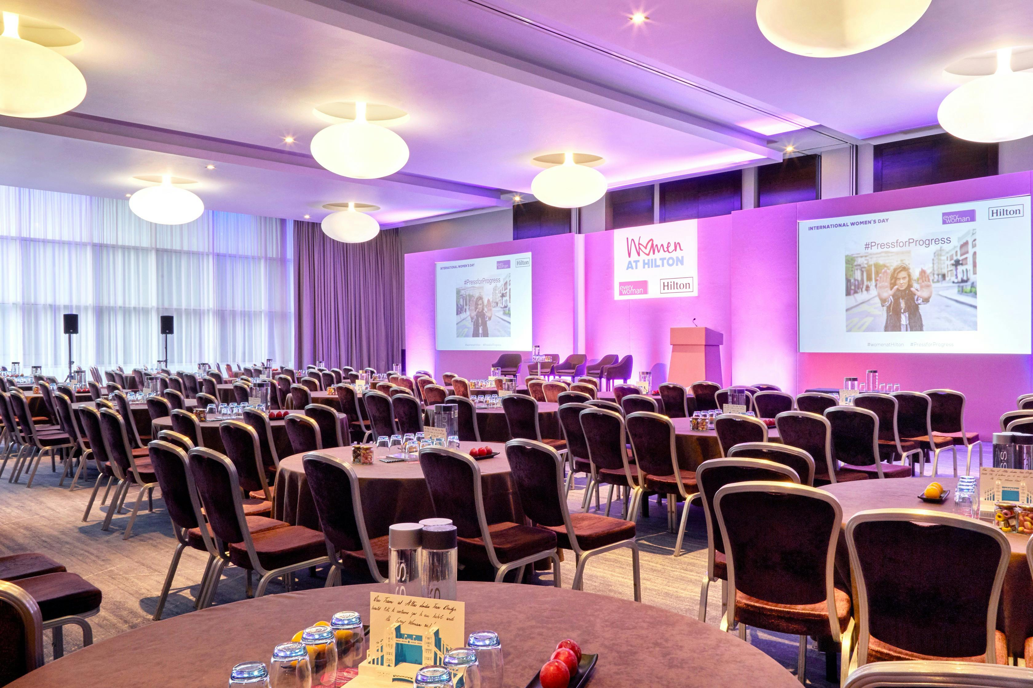 Tower Suite at Hilton London Tower Bridge, modern event space with round tables for conferences.