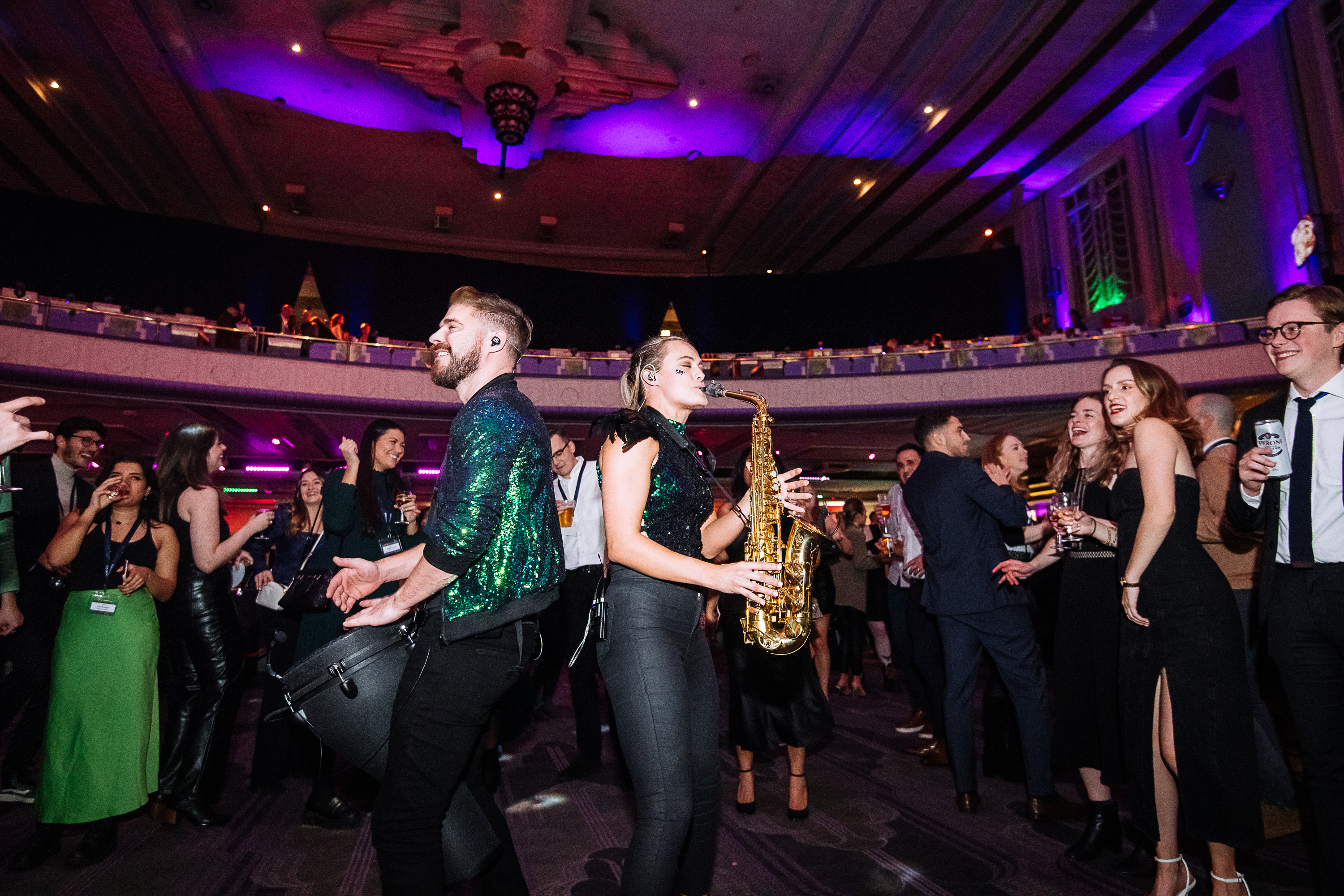 "Vibrant Grand Hall at Troxy with live music, dancing, and colorful lighting for celebrations." - Banner
