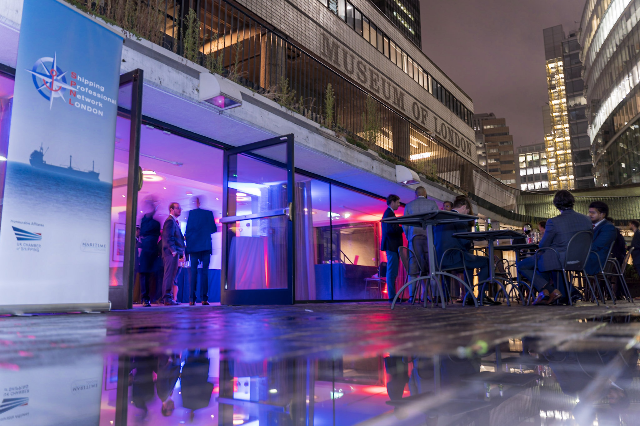 Vibrant evening event at London Museum with stylish entrance and colorful lighting. - Banner