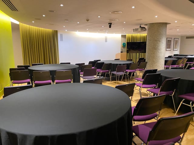 Terrace Gallery event space in London with round tables and modern purple chairs.