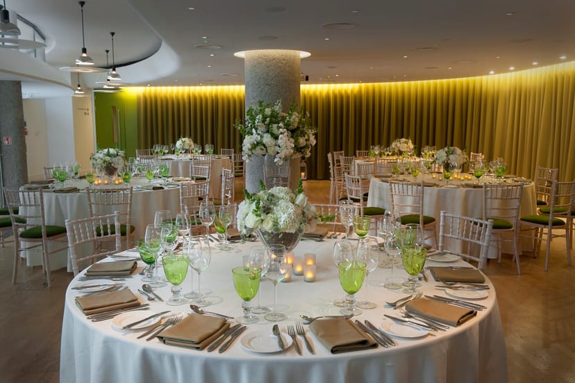 Elegant event space in Terrace Gallery, London with round tables and floral centerpieces.