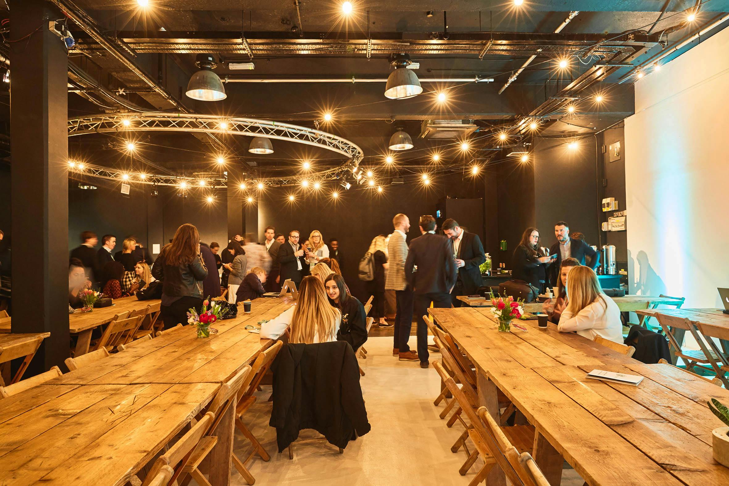 Vibrant event space with rustic tables, perfect for networking and social gatherings.