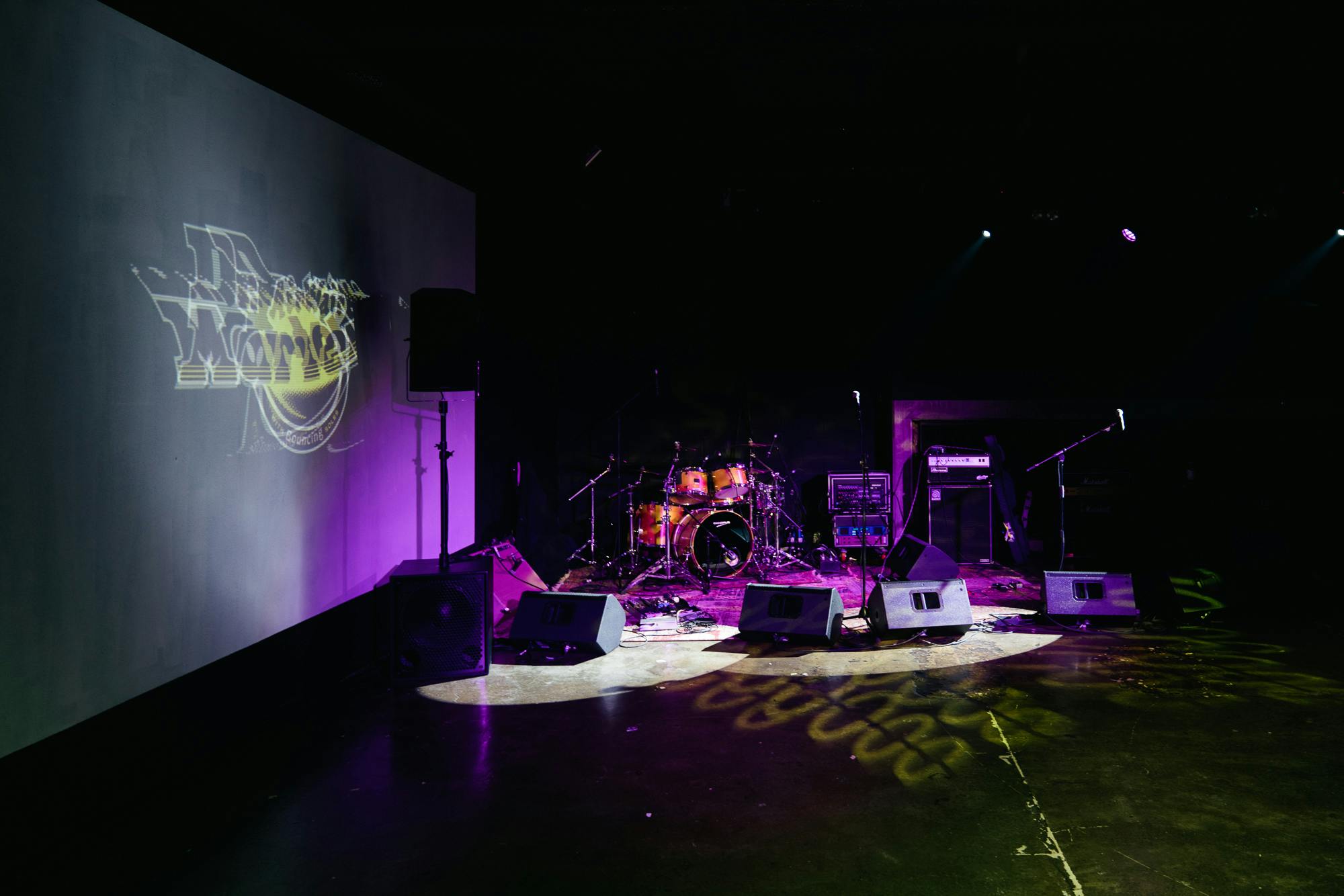 Black Studio stage setup with drum kit, ideal for concerts and corporate events.