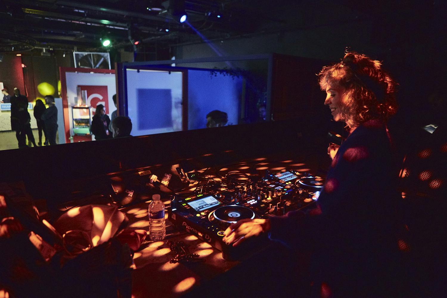 Vibrant event space with DJ, colorful lighting for networking and celebrations.
